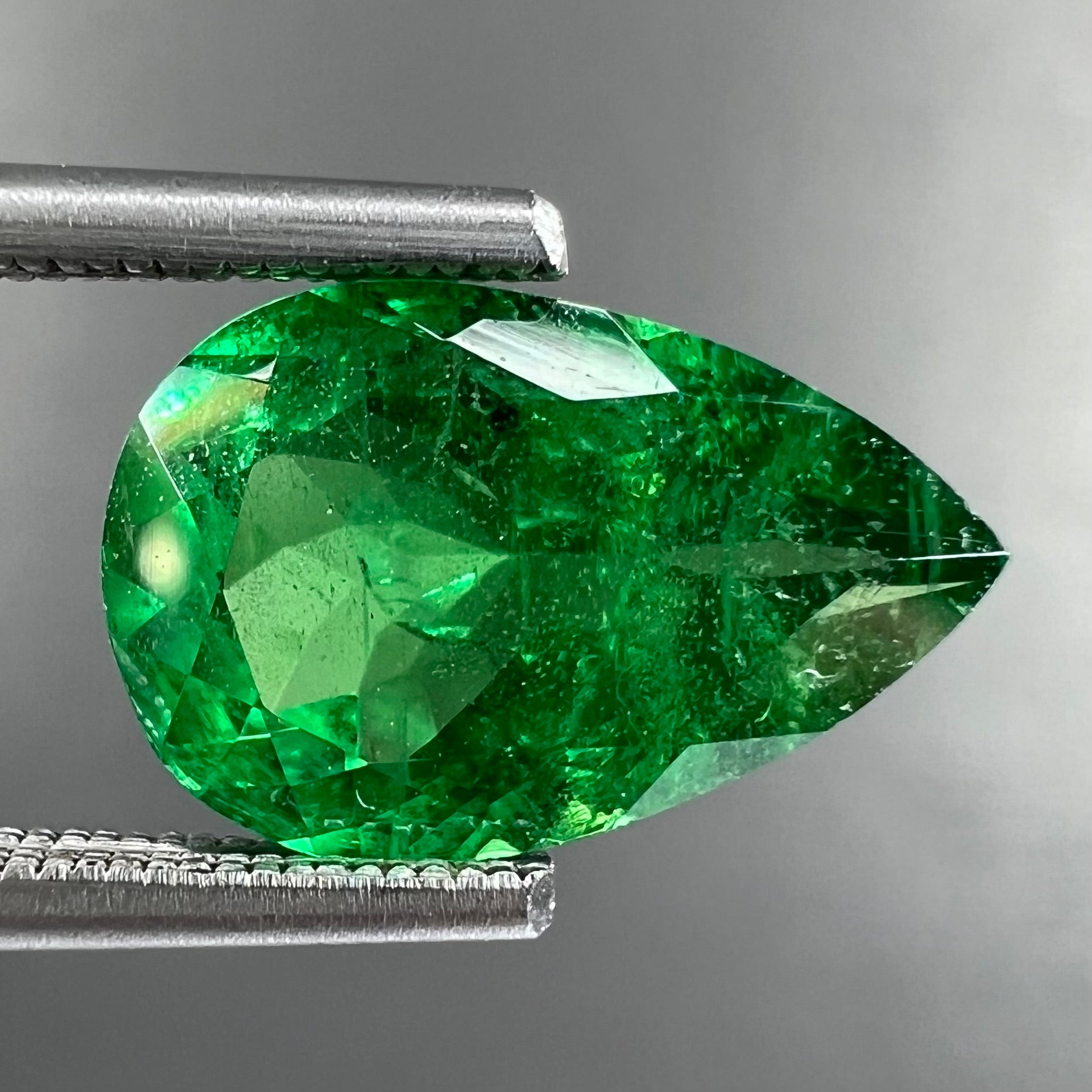 A loose, pear shaped tsavorite garnet gemstone.  The stone is vivid green color.