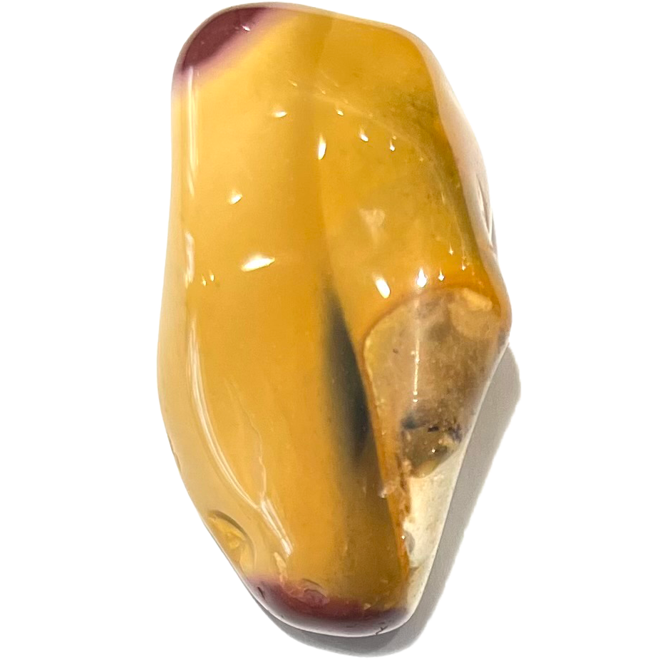 A tumbled mookaite jasper stone.  Red tips are visible on the predominantly yellow stone.