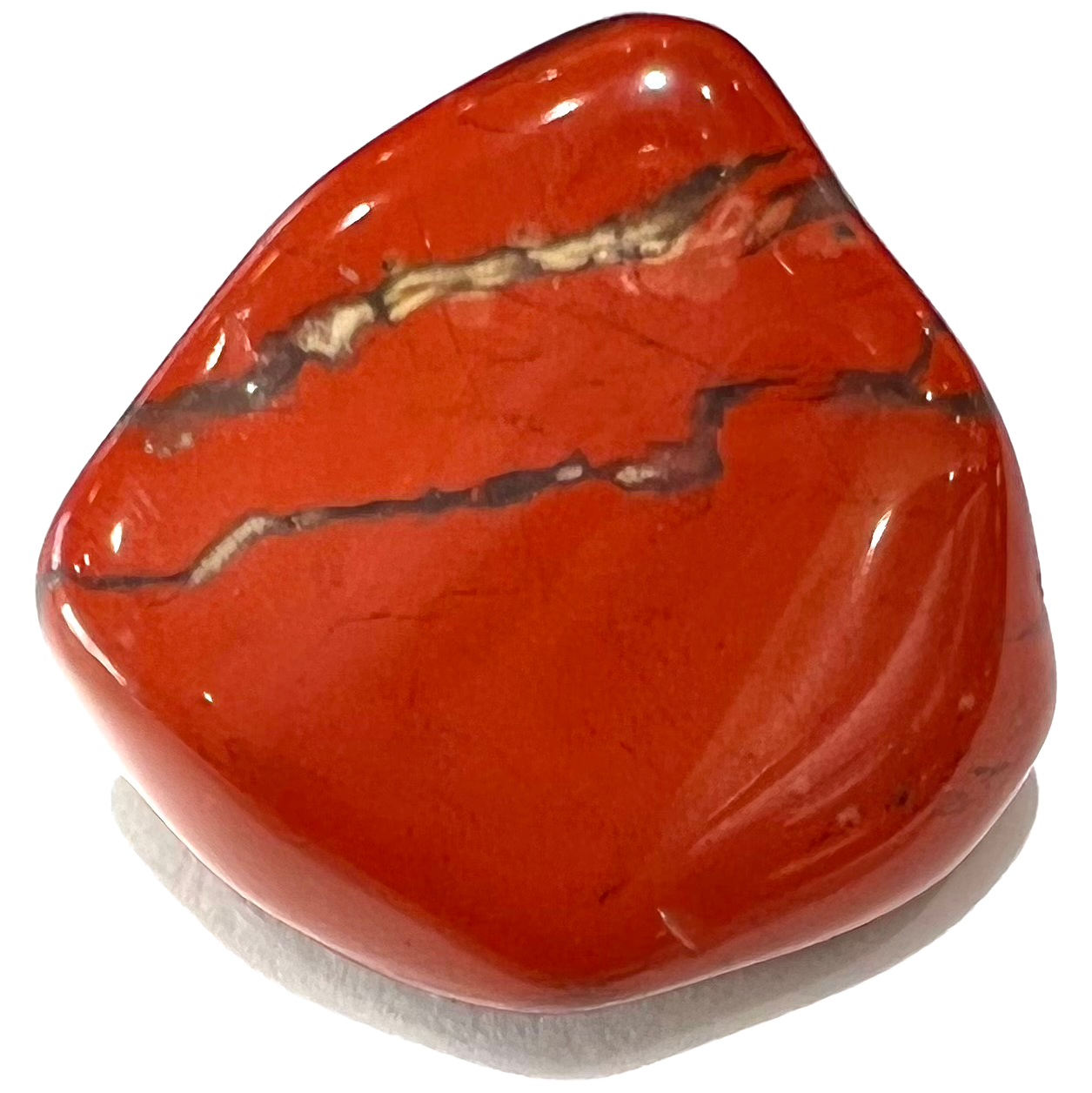 A tumbled red jasper stone.  Streaks of brown jasper run through the stone.