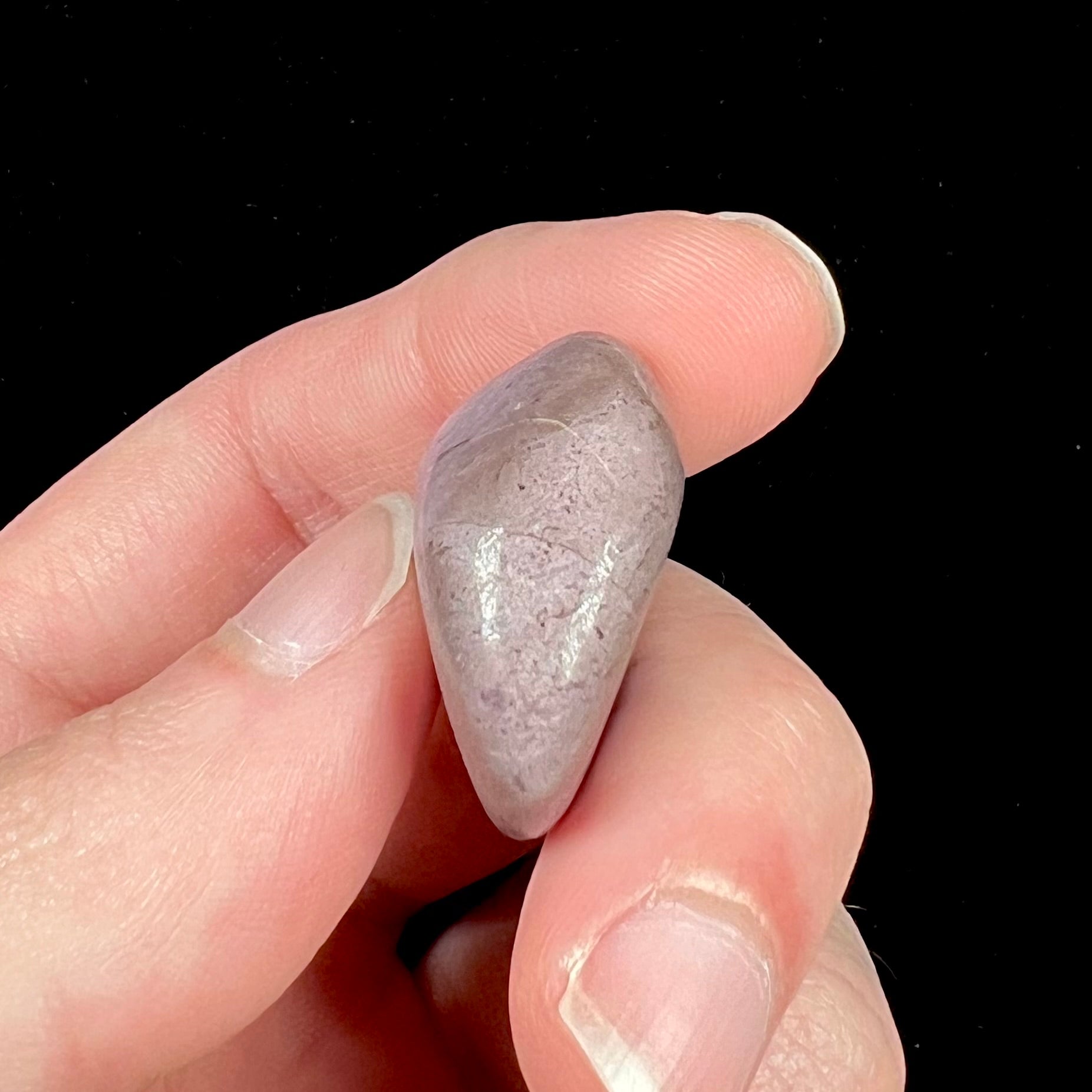A tumble polished turkiyenite purple jade stone from Bursa, Turkey.