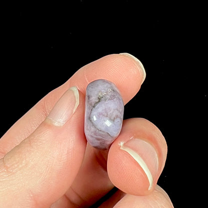 A tumble polished turkiyenite purple jade stone from Bursa, Turkey.  Material has reddish marbling.