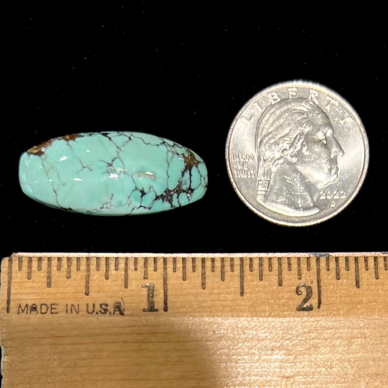 A loose, barrel cabochon cut Courtland-Gleeson turquoise stone.  The stone is greenish blue with black and brown matrix.