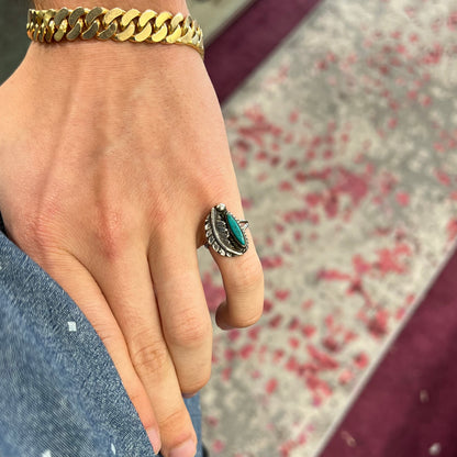 A ladies' sterling silver feather style ring set with a marquise cut turquoise stone.