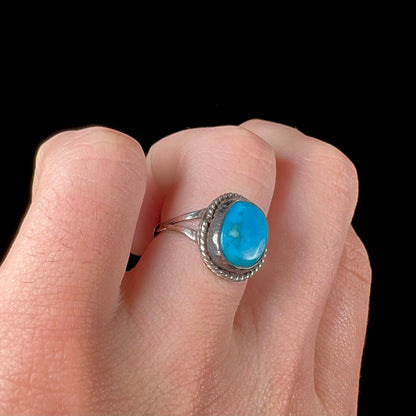 A vintage ladies' Pilot Mountain turquoise ring handmade in sterling silver with a rope accented bezel.