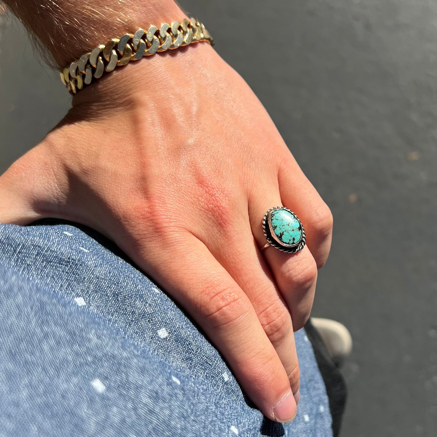 A handmade ladies' turquoise solitaire ring.  The ring has a rope bezel design.