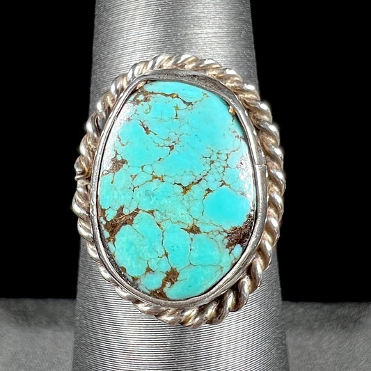 A handmade ladies' turquoise solitaire ring.  The ring has a rope bezel design.