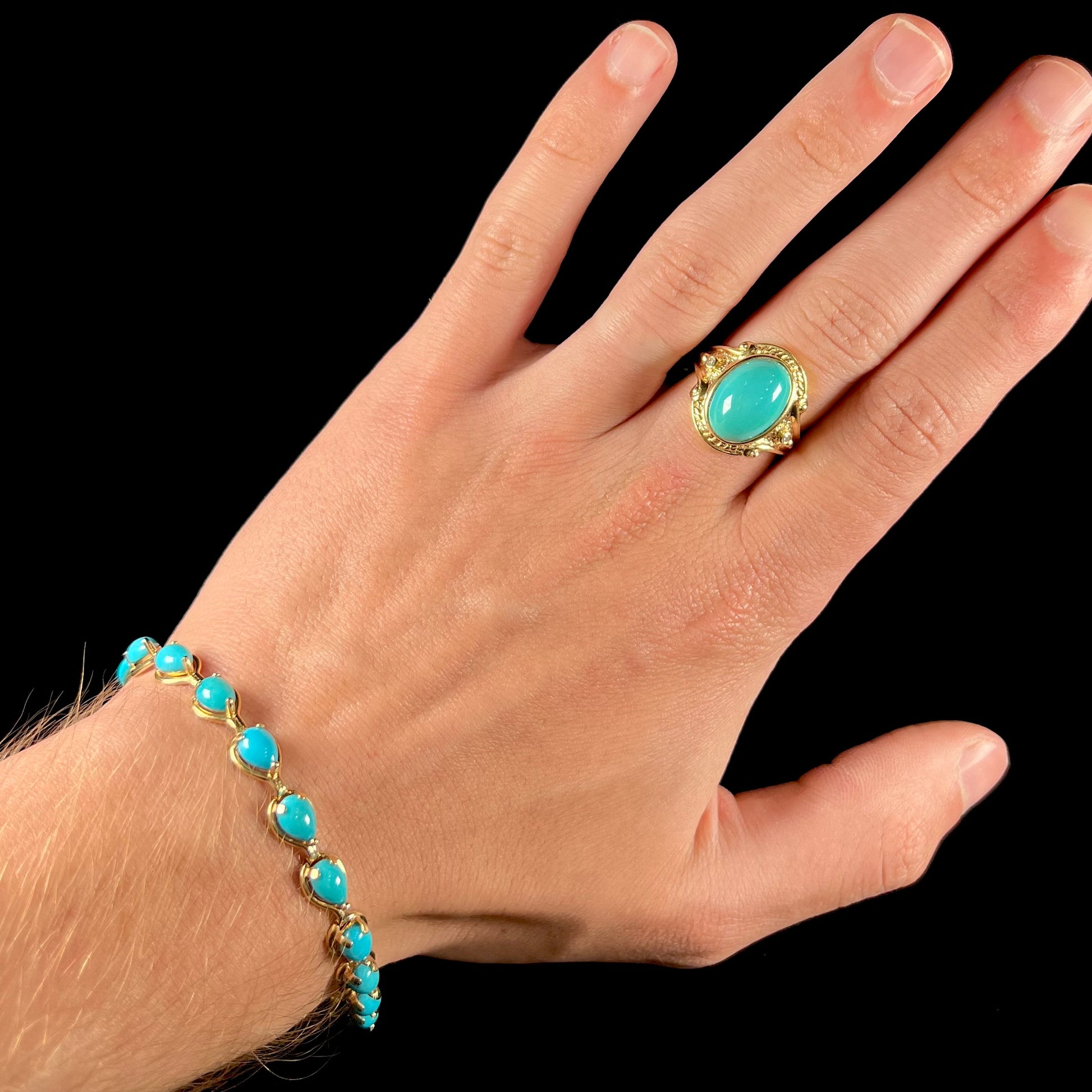 A ladies' yellow gold tennis style bracelet set with pear cabochon shaped natural Sleeping Beauty turquoise stones.