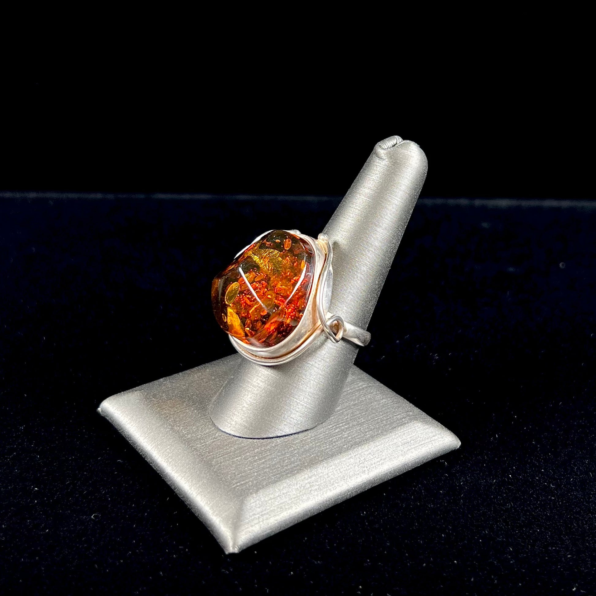 Unisex sterling silver ring set with a sun-spangled Baltic amber gemstone.