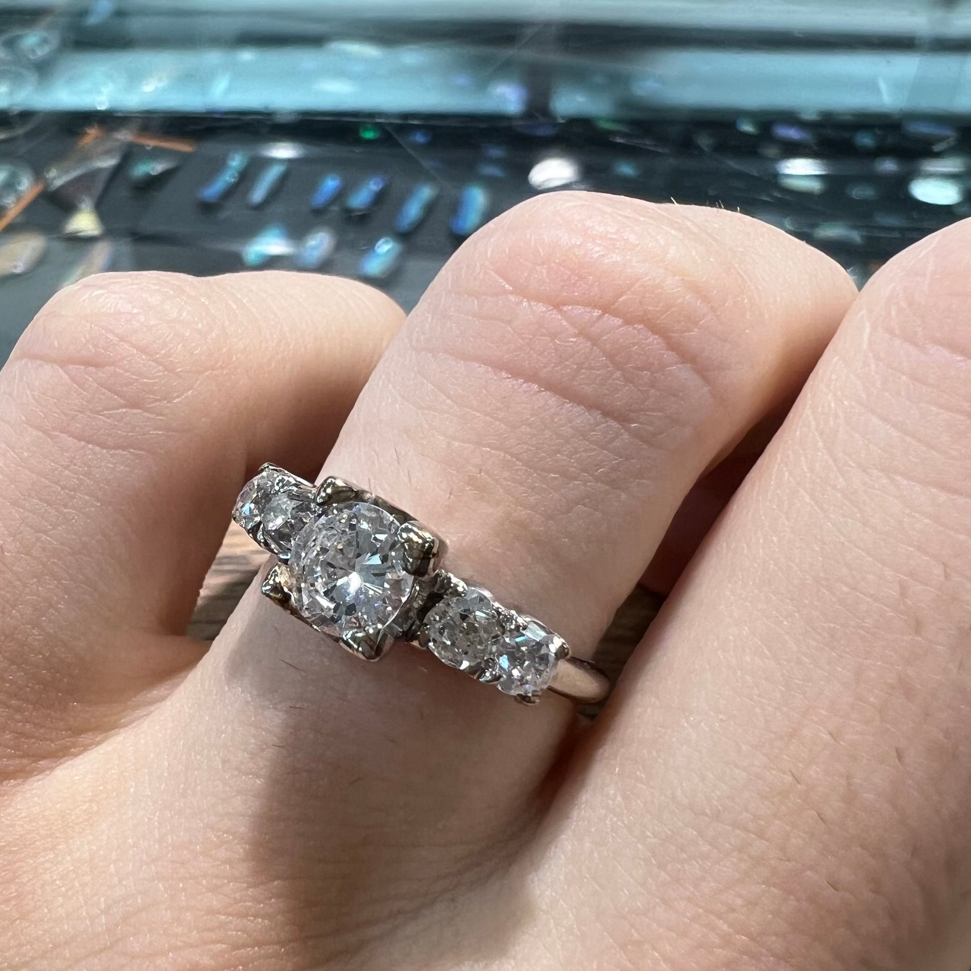 A ladies' 1800's antique white gold diamond ring.  The center stone is an Early American Cut diamond, and the accent stones are Old Mine Cut diamonds.