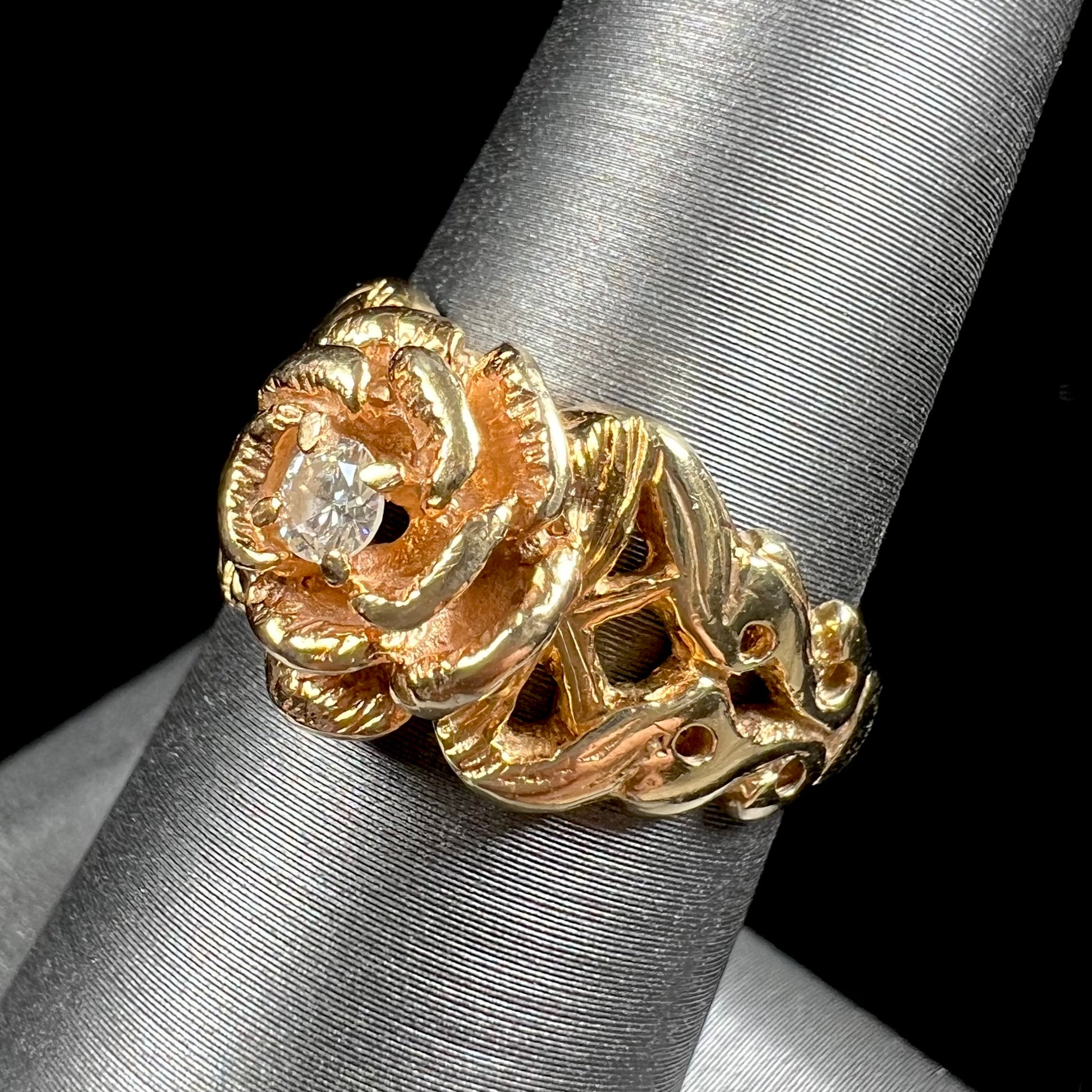 A ladies' yellow gold rose style ring set with a natural 0.10ct diamond.