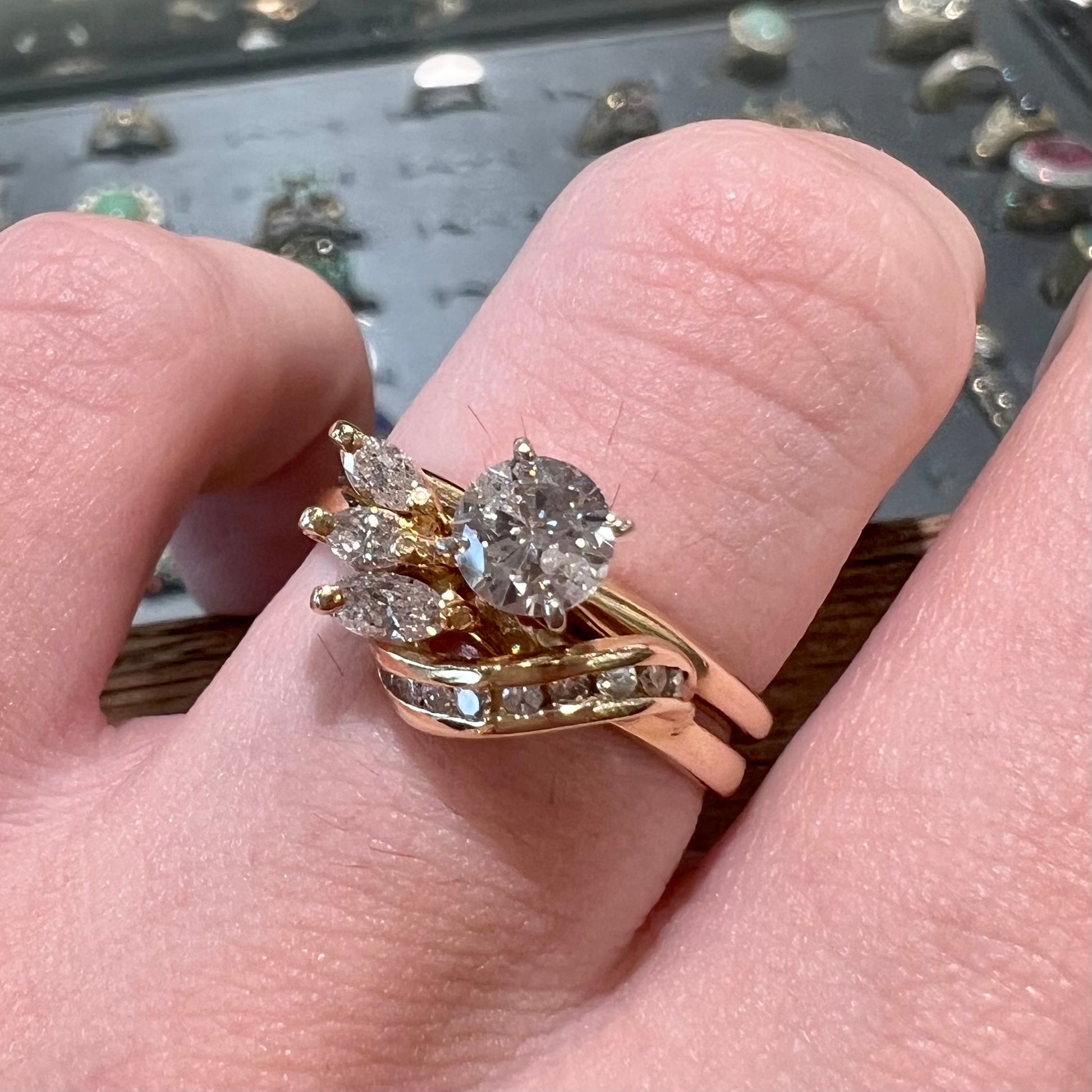 A vintage diamond wedding set with a round brilliant cut center stone and marquise cut accents in yellow gold.