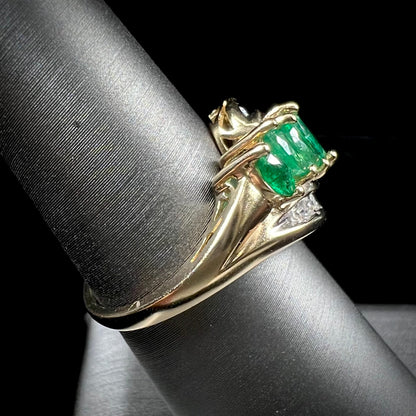 A vintage, 1970's style yellow gold ring set with marquise cut emeralds and round brilliant cut diamonds.