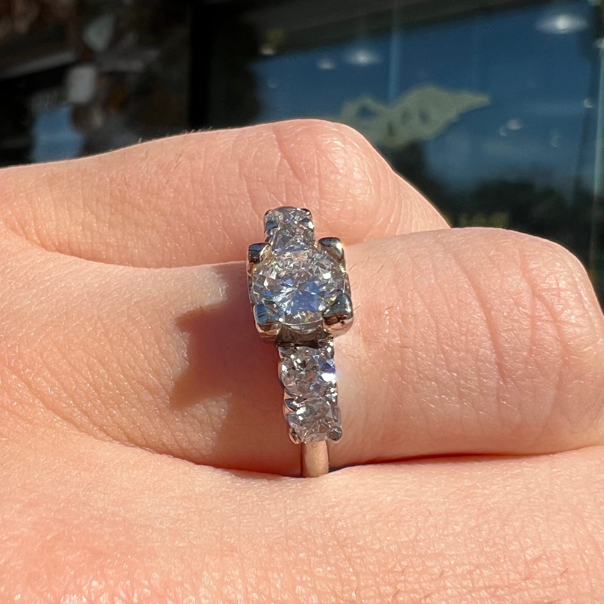 A ladies' 1800's antique white gold diamond ring.  The center stone is an Early American Cut diamond, and the accent stones are Old Mine Cut diamonds.