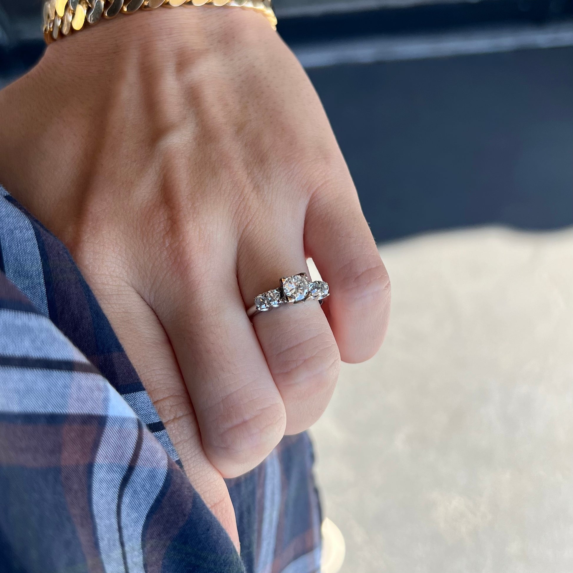 A ladies' 1800's antique white gold diamond ring.  The center stone is an Early American Cut diamond, and the accent stones are Old Mine Cut diamonds.