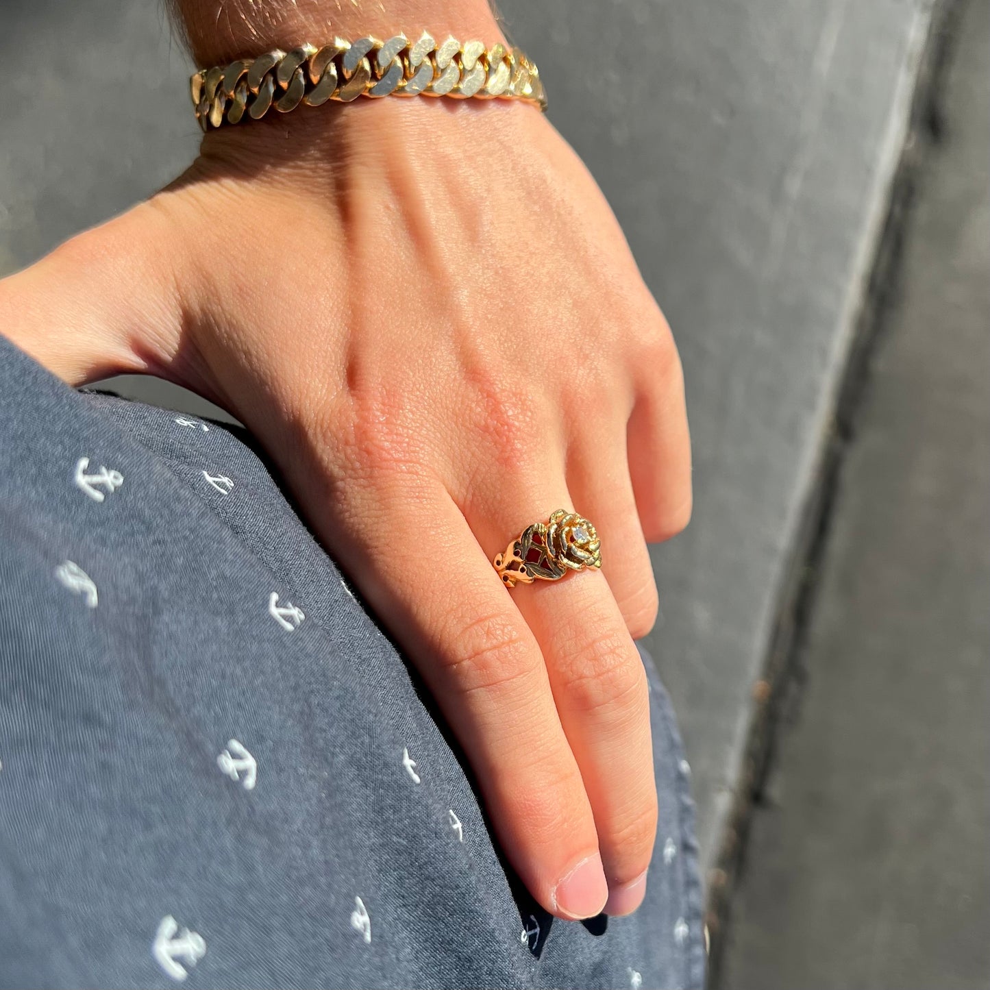 A ladies' yellow gold rose style ring set with a natural 0.10ct diamond.