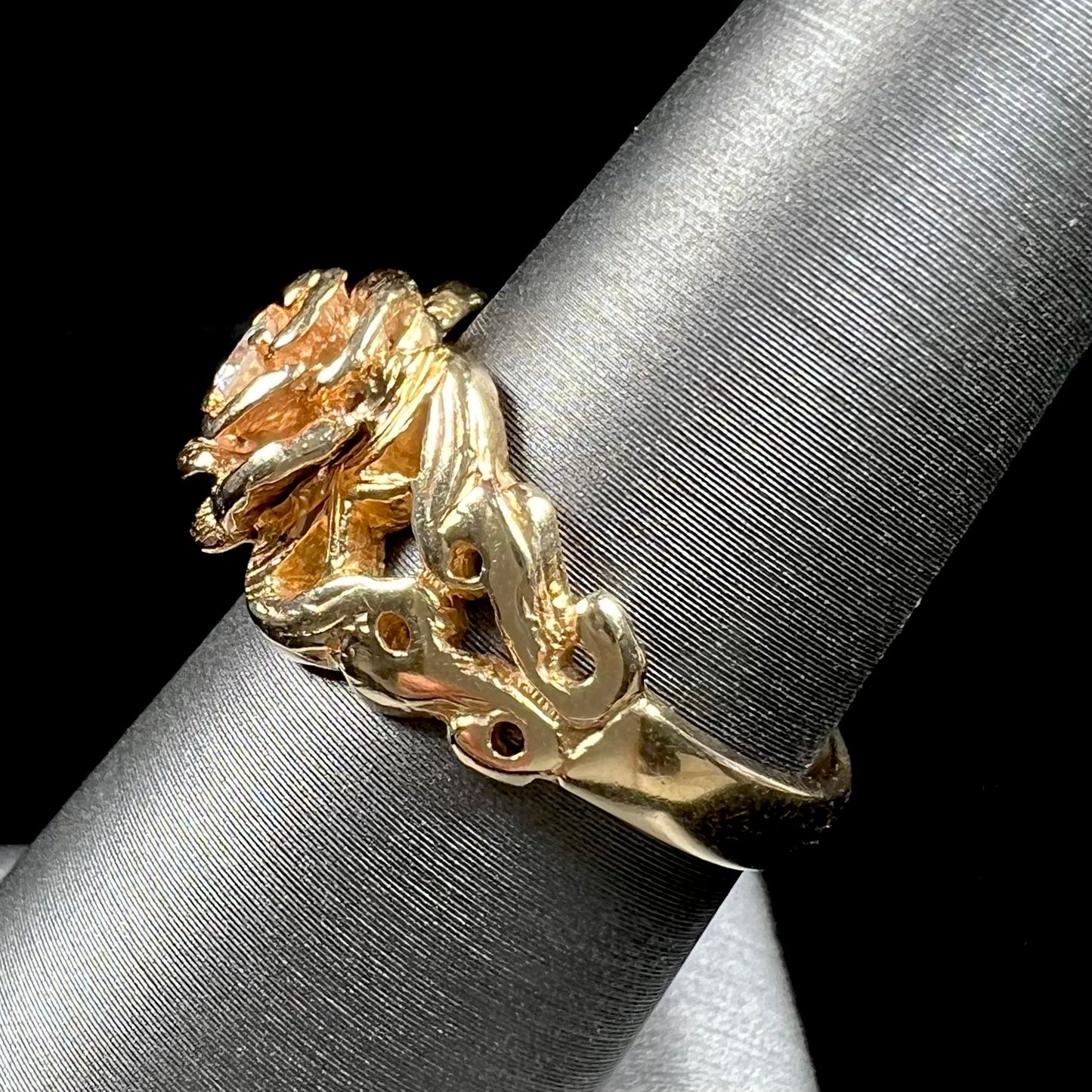 A ladies' yellow gold rose style ring set with a natural 0.10ct diamond.