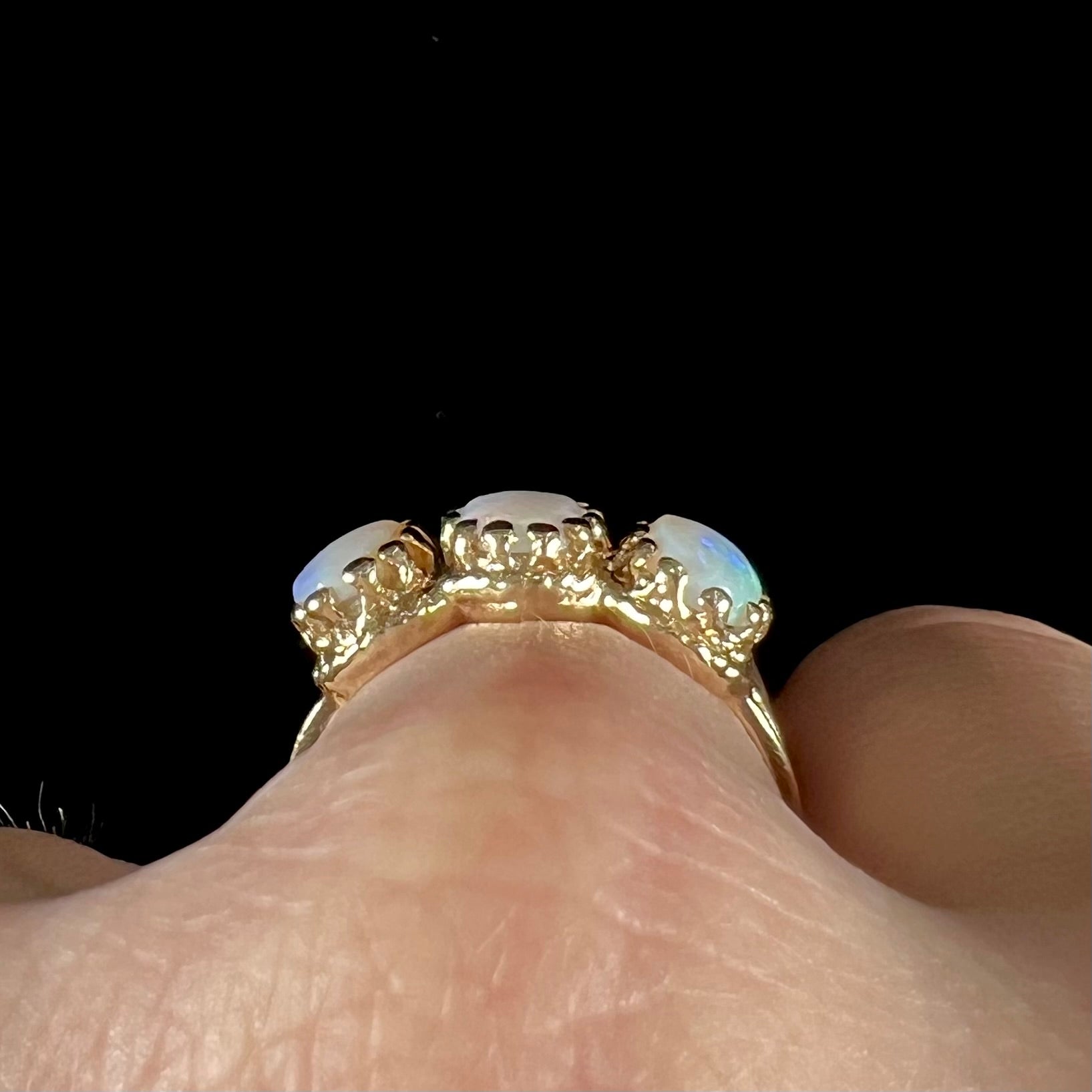 A vintage ladies' three stone gold ring set with natural white crystal opals.