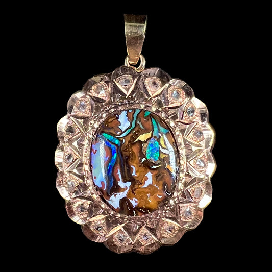 An antique 18 karat yellow gold pendant set with rough diamonds and an oval cut boulder opal from Koroit, Australia.