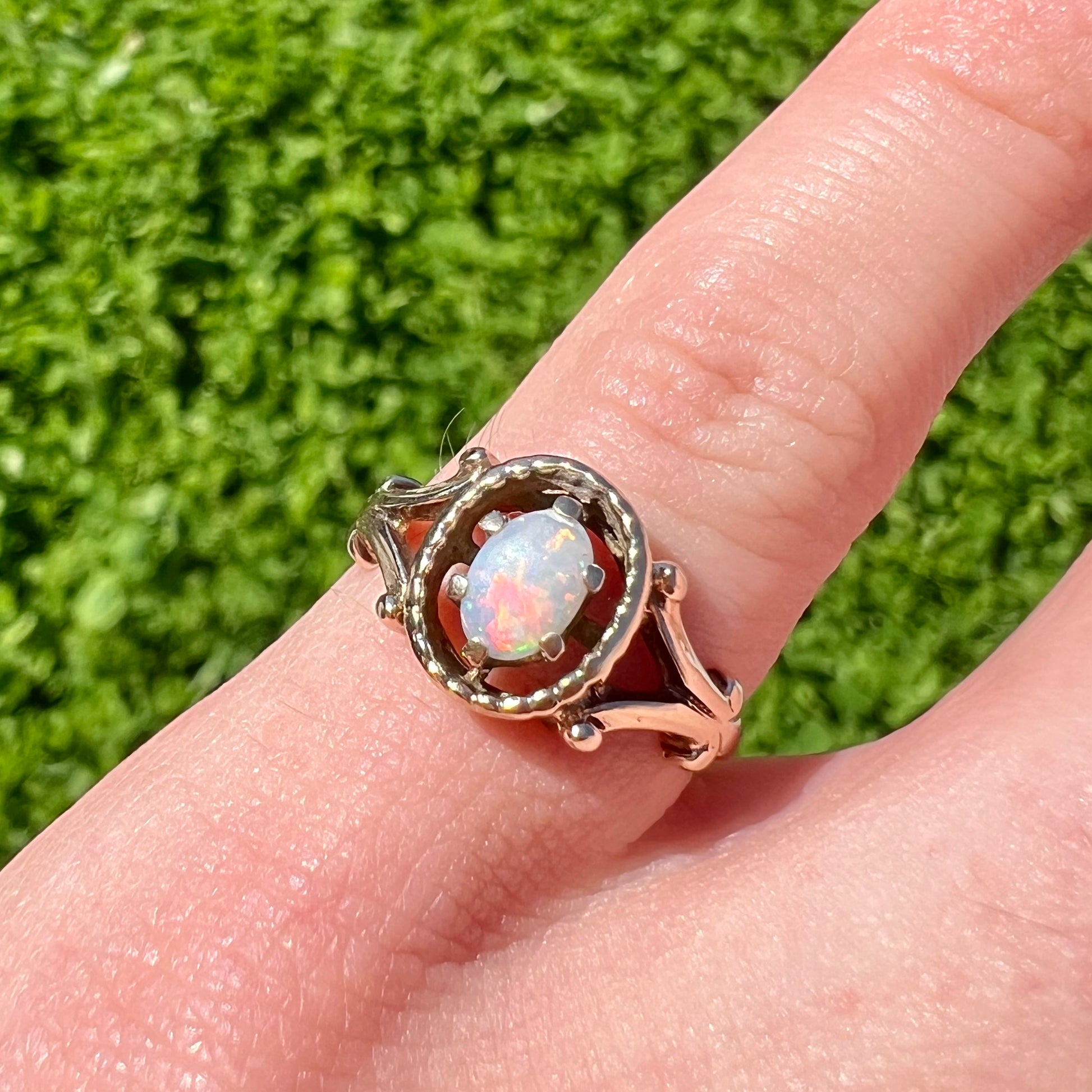 A ladies' yellow gold opal ring.  The ring has a filigree Art Nouveau style.