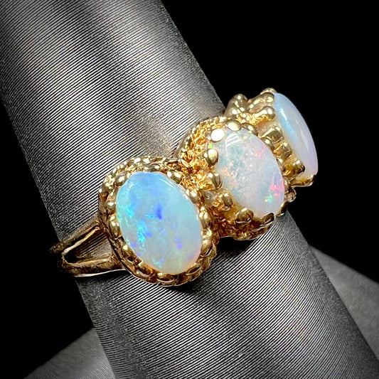 A vintage ladies' three stone gold ring set with natural white crystal opals.