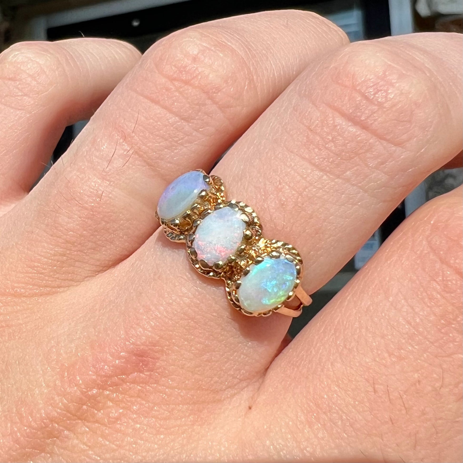 A vintage ladies' three stone gold ring set with natural white crystal opals.