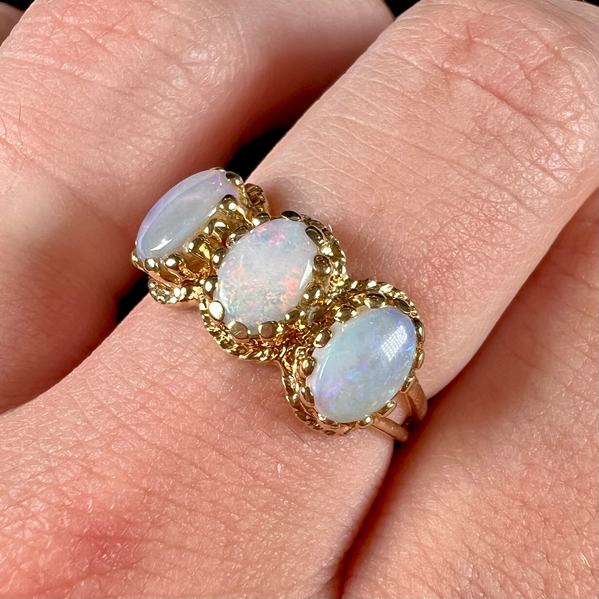 A vintage ladies' three stone gold ring set with natural white crystal opals.