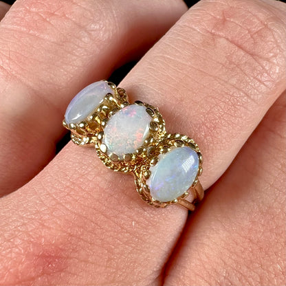 A vintage ladies' three stone gold ring set with natural white crystal opals.