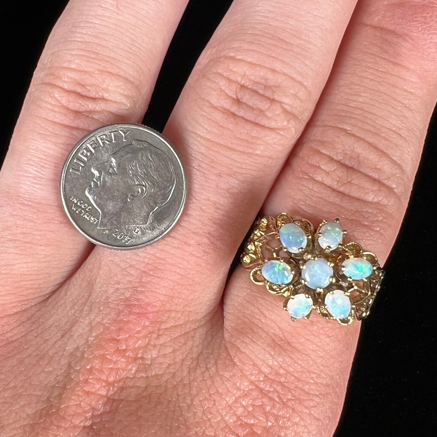 A vintage, 1950's style opal cluster ring cast in yellow gold with a heart shaped filigree design.