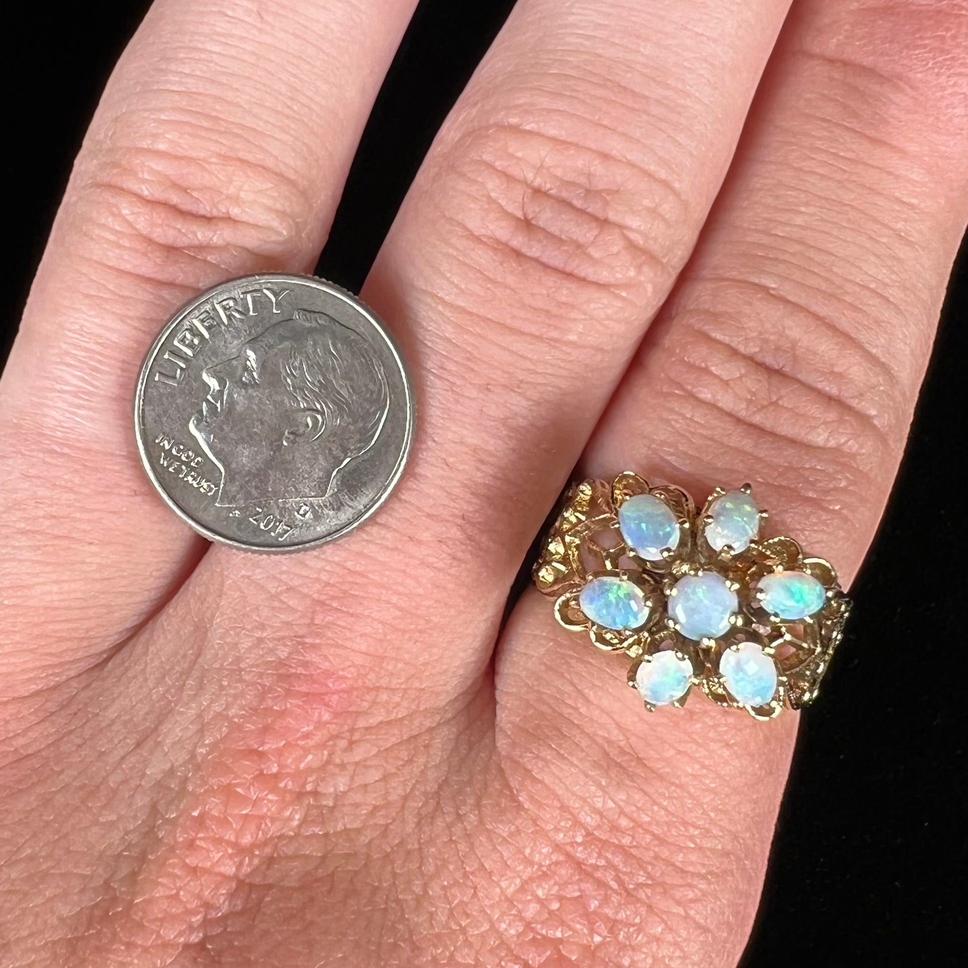 A vintage, 1950's style opal cluster ring cast in yellow gold with a heart shaped filigree design.
