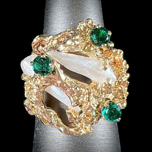 A vintage 1950's gold cluster ring set with freshwater pearls and green imitation emeralds.