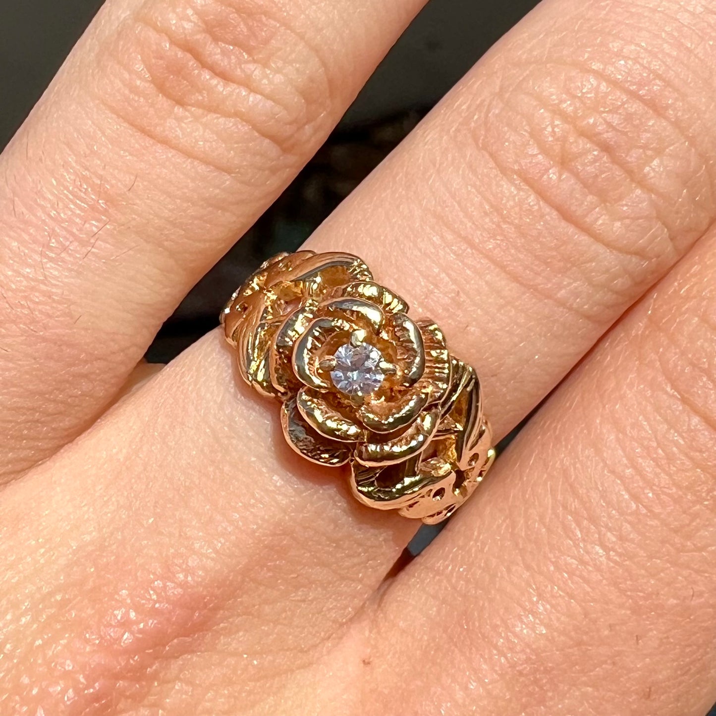 A ladies' yellow gold rose style ring set with a natural 0.10ct diamond.