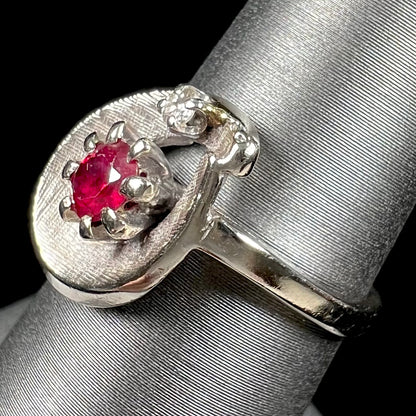 A ladies' estate white gold ruby ring set with a diamond accent stone.