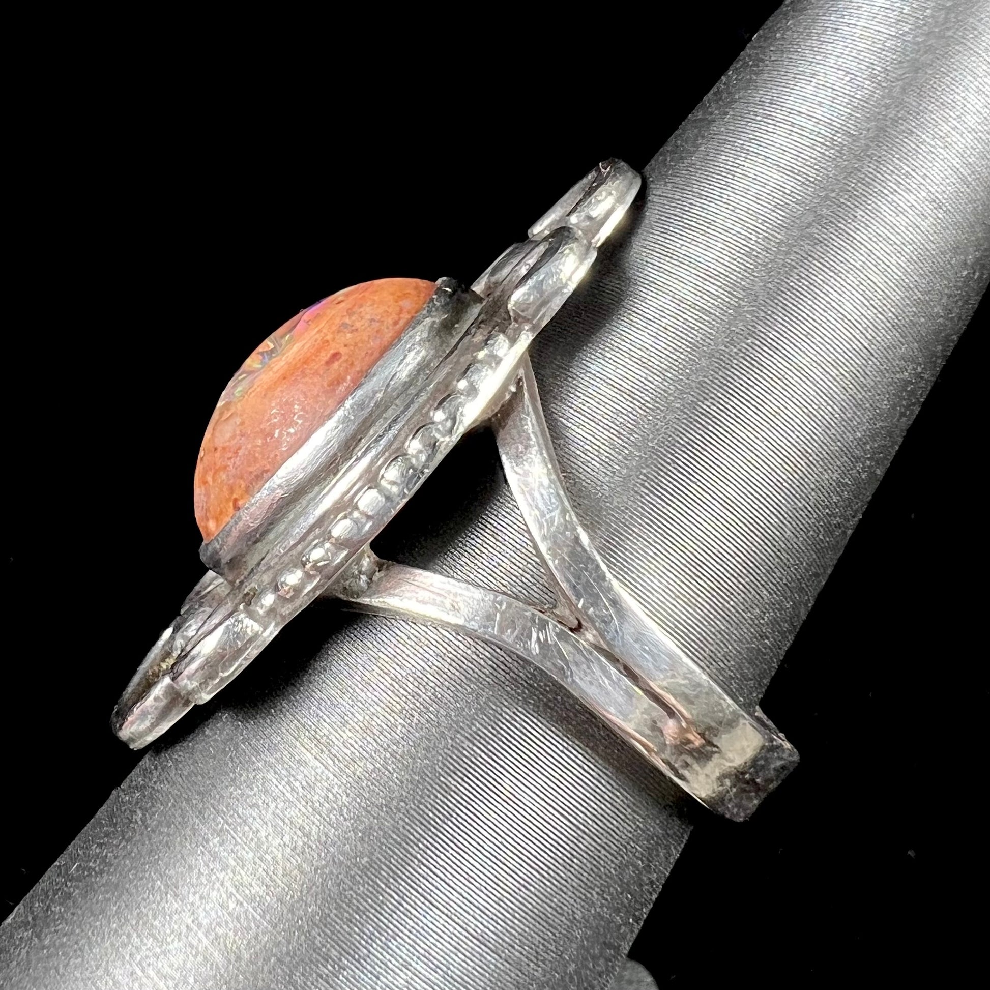 A vintage, Navajo style sterling silver ring set with an oval cabochon cut cantera fire opal stone.