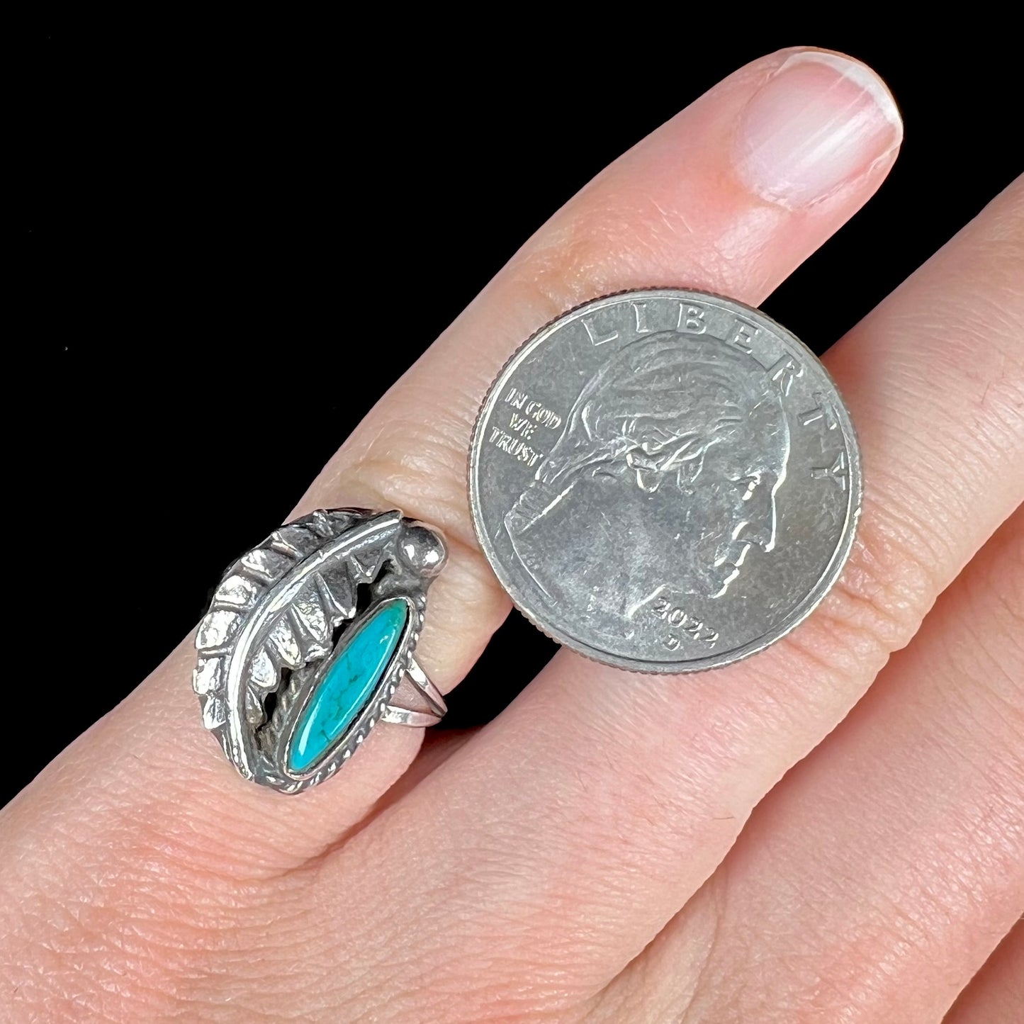 A ladies' sterling silver feather style ring set with a marquise cut turquoise stone.
