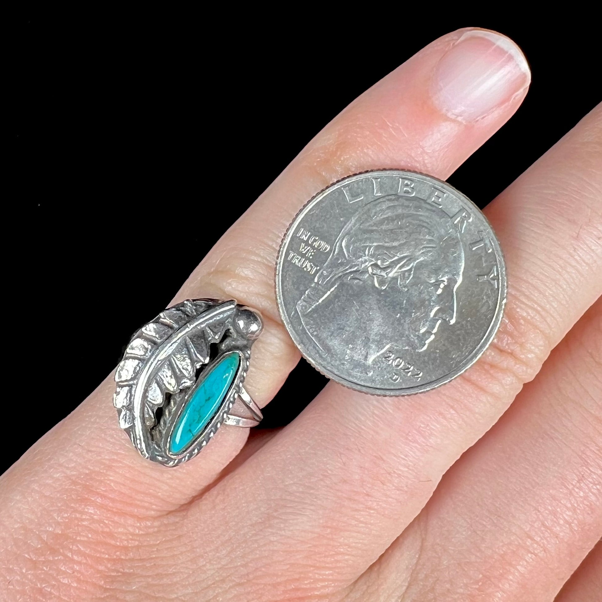 A ladies' sterling silver feather style ring set with a marquise cut turquoise stone.