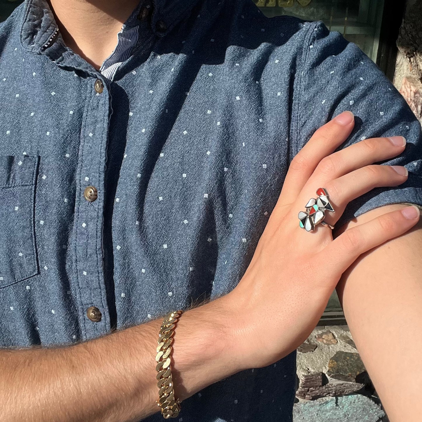 A vintage, sterling silver Zuni thunderbird ring inlaid with turquoise, mother of pearl, onyx, and coral stones.