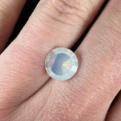 A loose, yellowish-white bodied Mexican fire opal.  The stone is a faceted round cut.