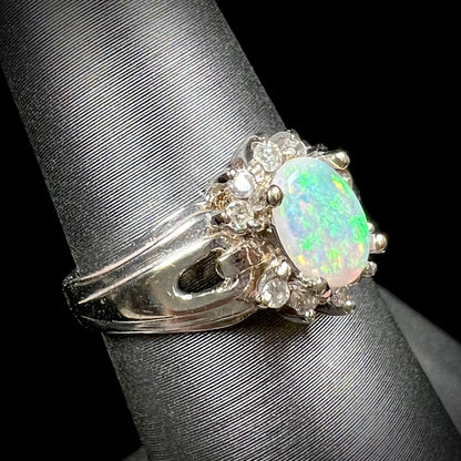A ladies' white gold ring set with a halo of diamonds and an oval cabochon cut Australian opal.