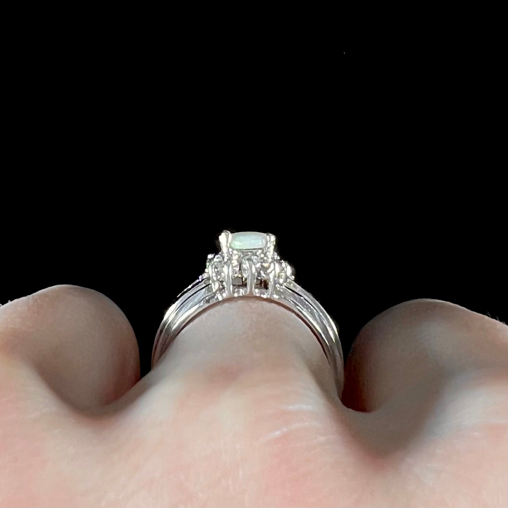 A ladies' white gold ring set with a halo of diamonds and an oval cabochon cut Australian opal.