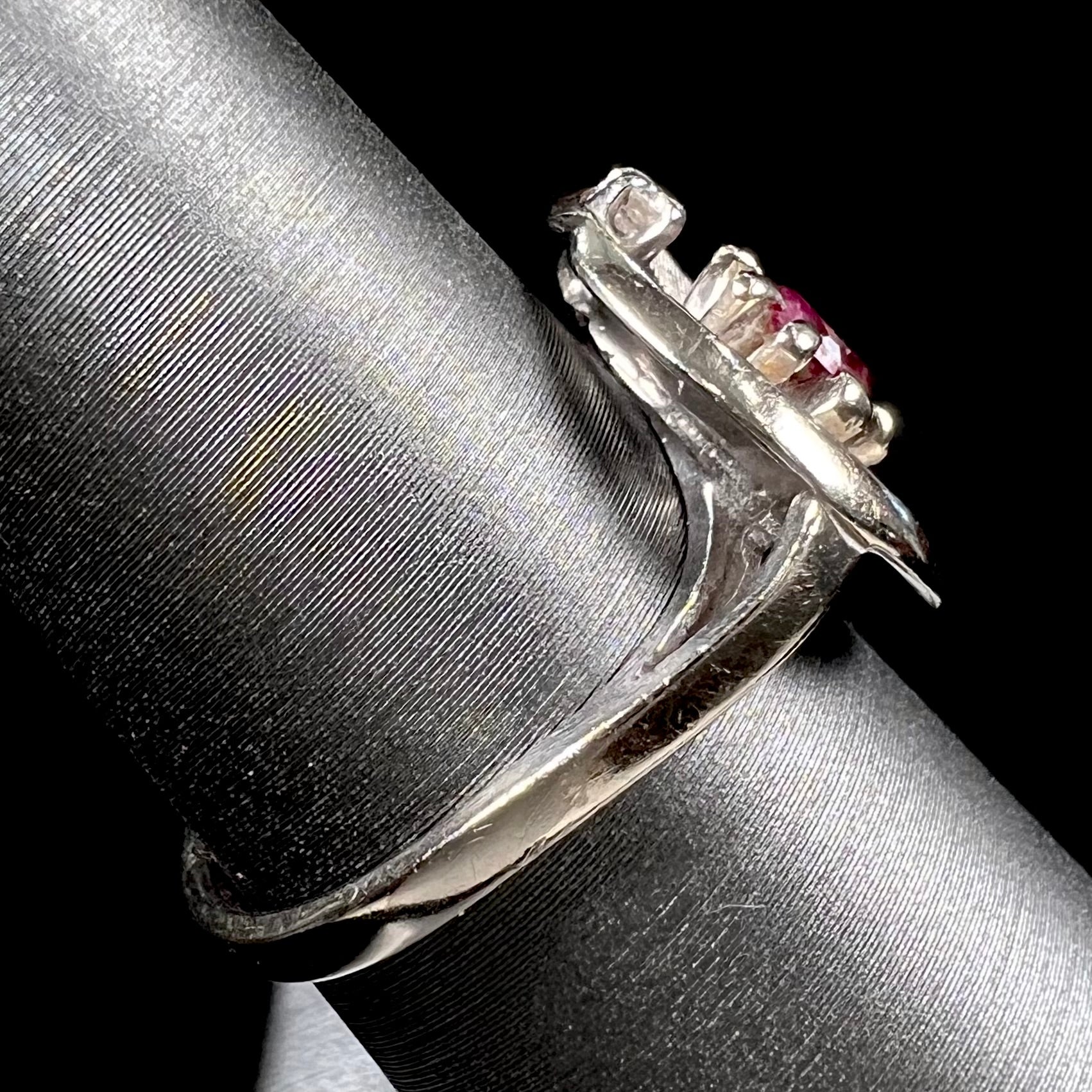 A ladies' estate white gold ruby ring set with a diamond accent stone.