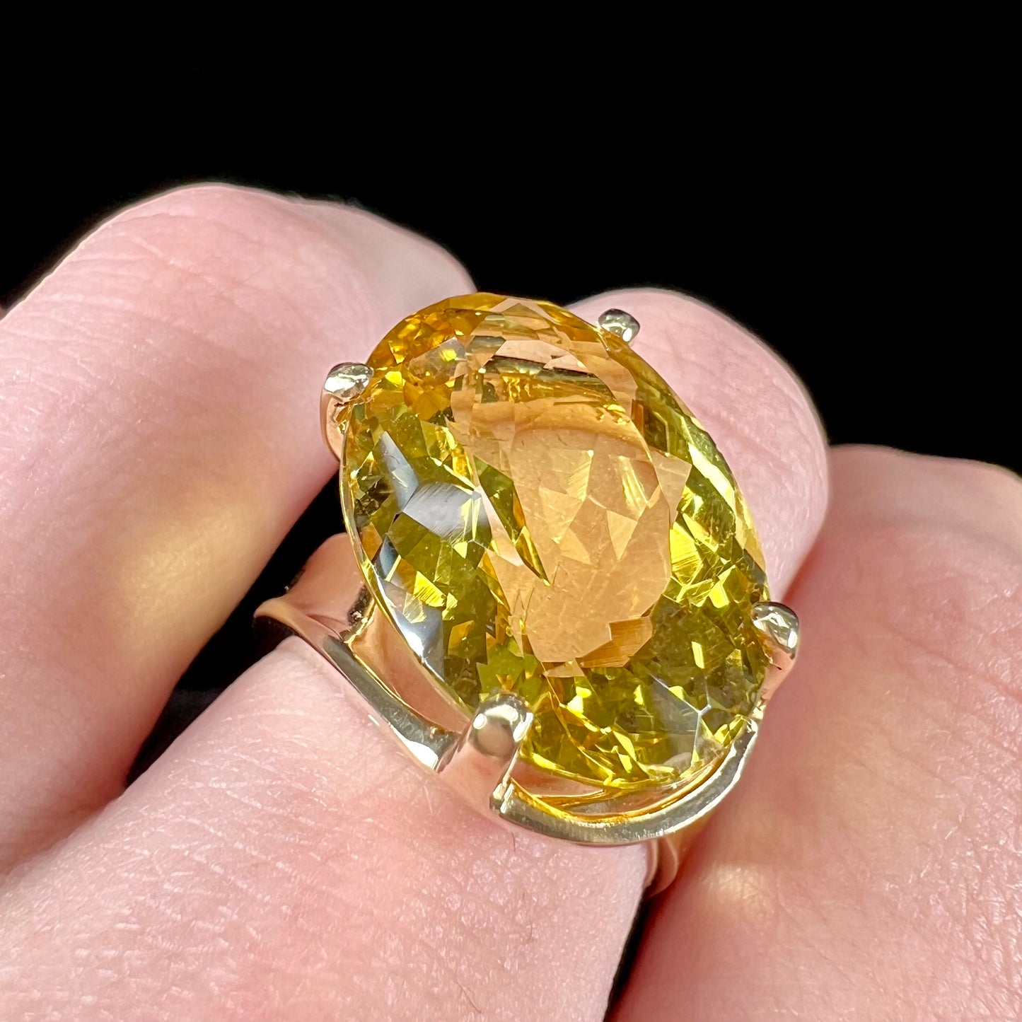 An 18 karat yellow gold solitaire cocktail ring set with a faceted oval cut golden beryl gemstone.