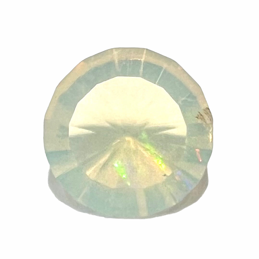 A loose, yellowish-white bodied Mexican fire opal.  The stone is a faceted round cut.