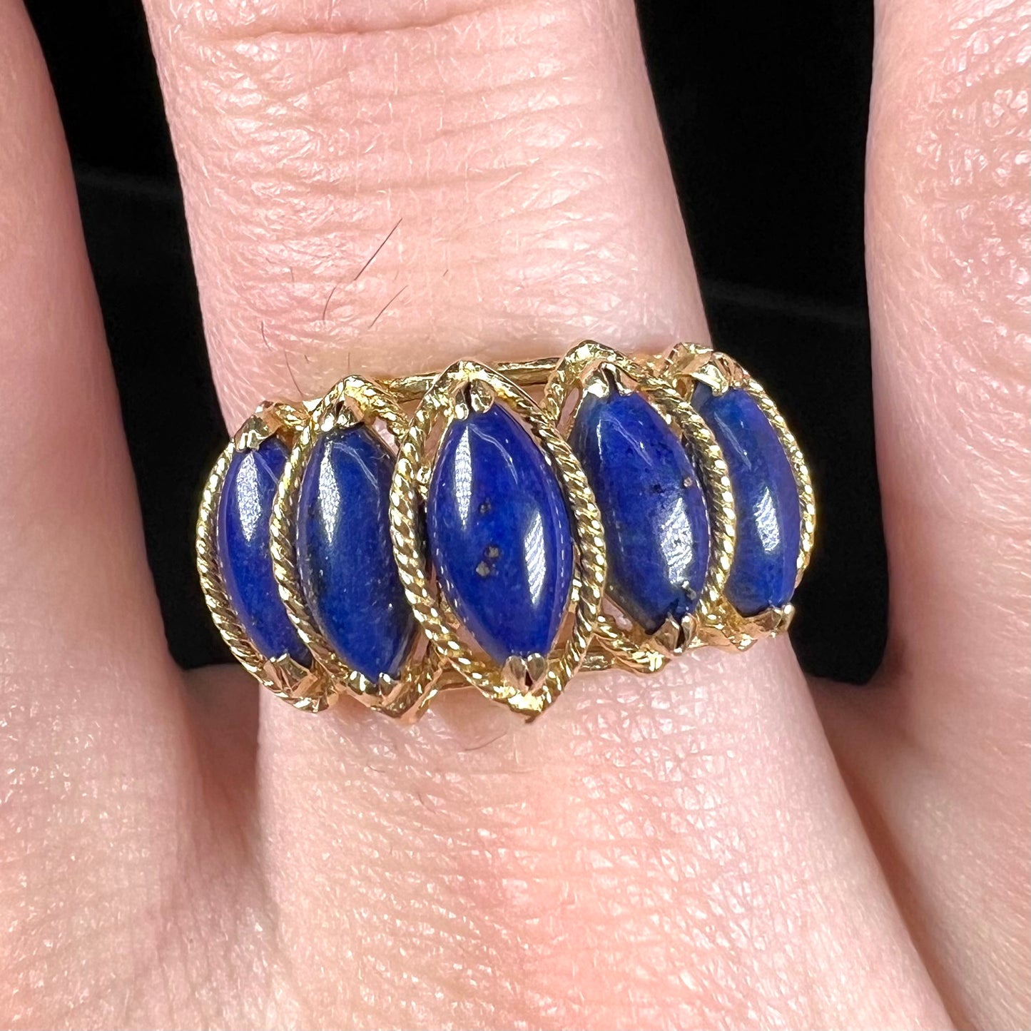 A ladies' five stone marquise cabochon cut lapis lazuli ring in yellow gold.