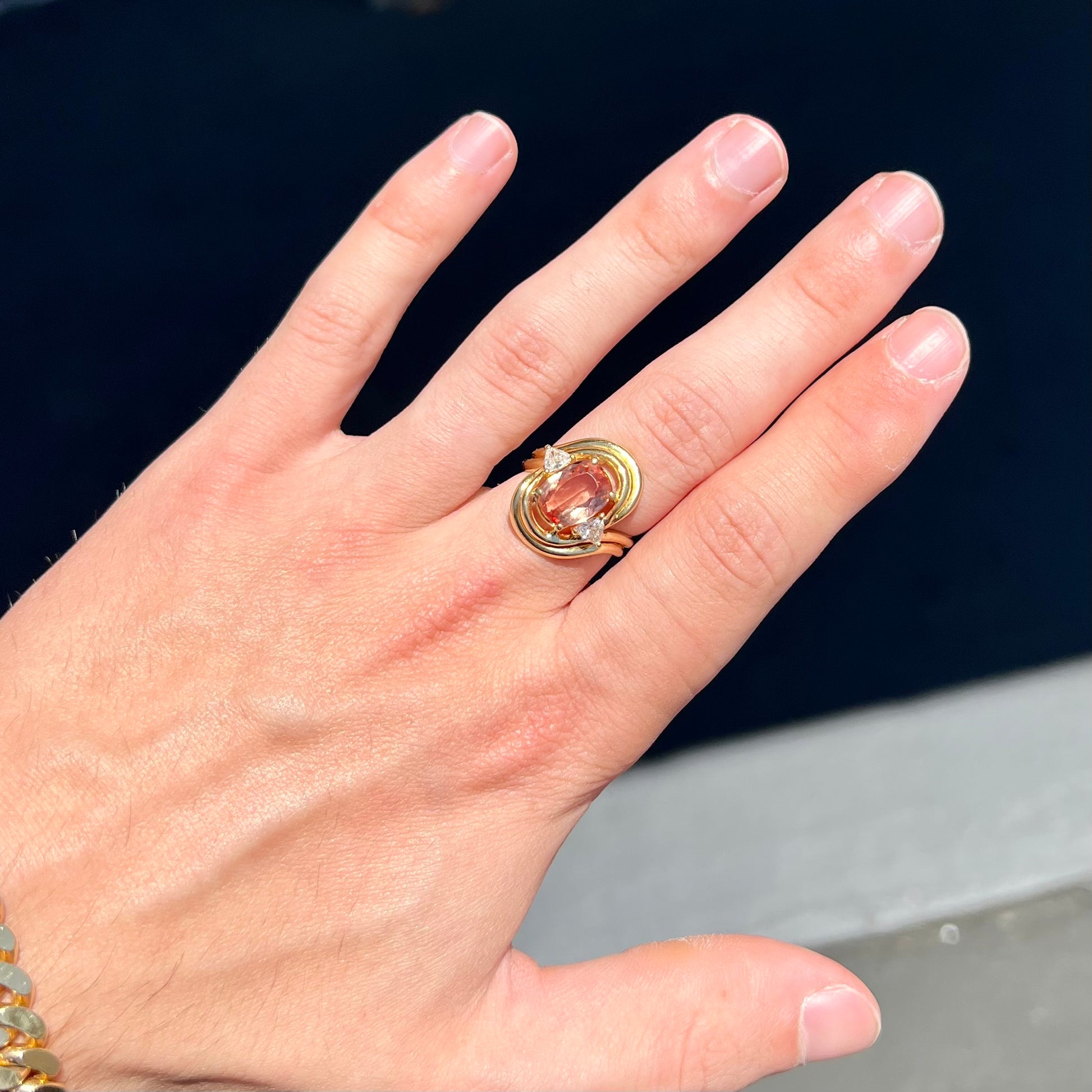 An 18 karat yellow gold ring set with two triangle cut diamonds and a cushion cut imperial topaz.