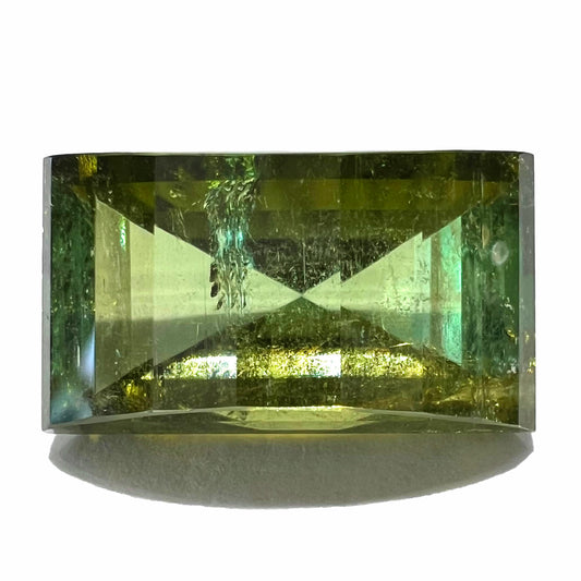 A rectangular step-cut yellowish green tourmaline gemstone.