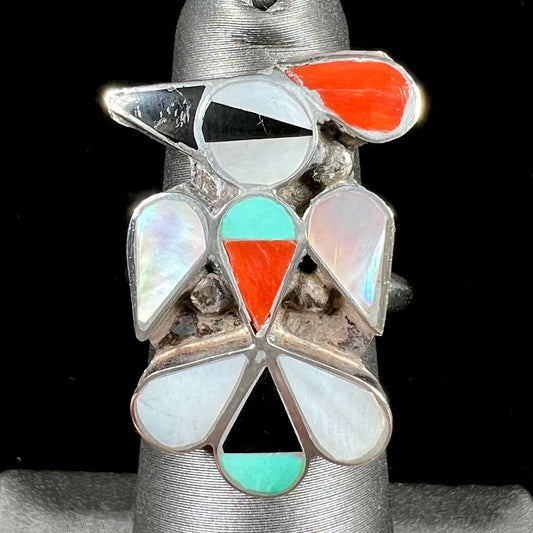 A vintage, sterling silver Zuni thunderbird ring inlaid with turquoise, mother of pearl, onyx, and coral stones.