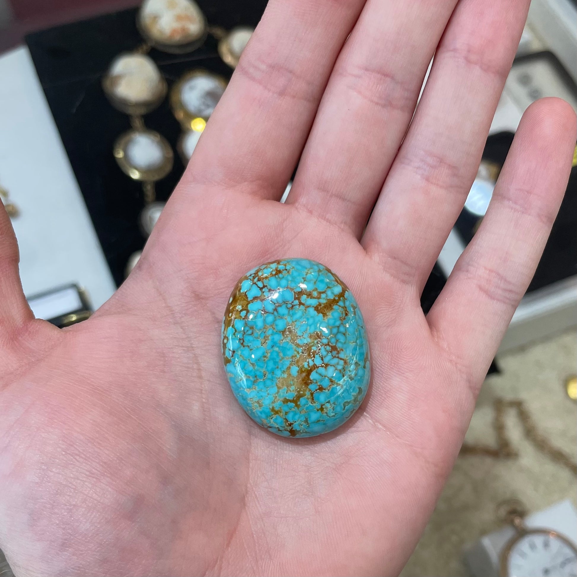 A loose, oval cut turquoise cabochon from Number 8 Mine, Nevada.  The stone is blue with a golden brown webbed matrix.