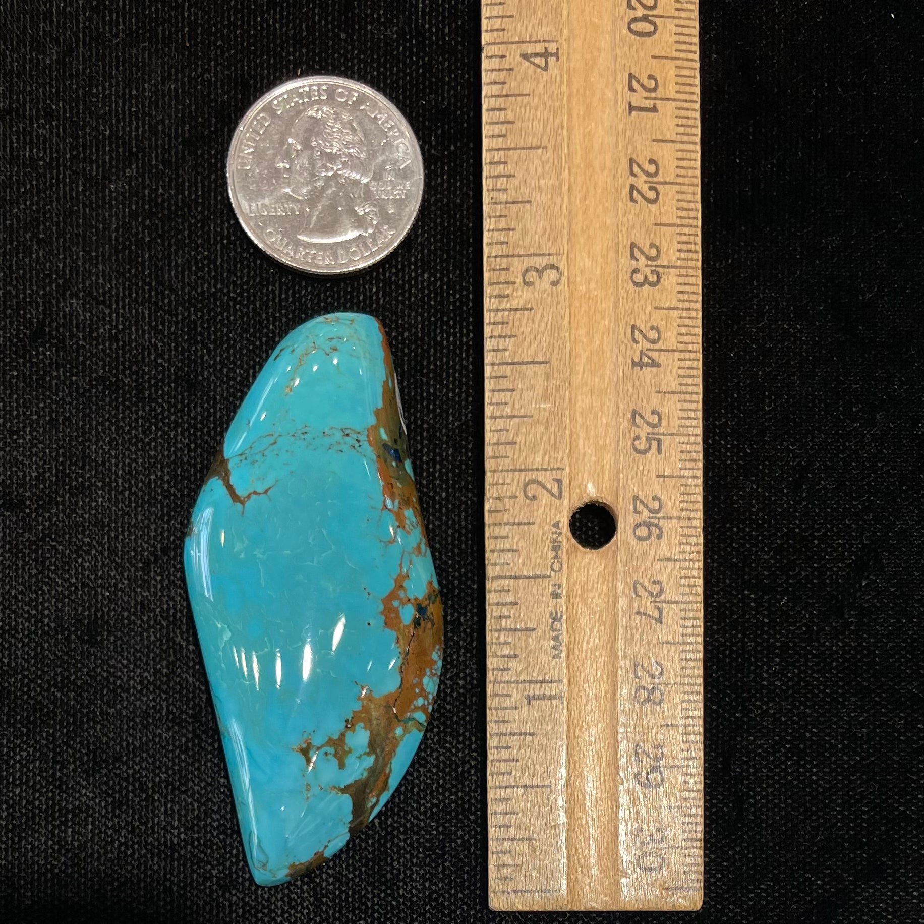 A freeform cabochon cut Bisbee turquoise stone.  The stone has been dyed to improve color.