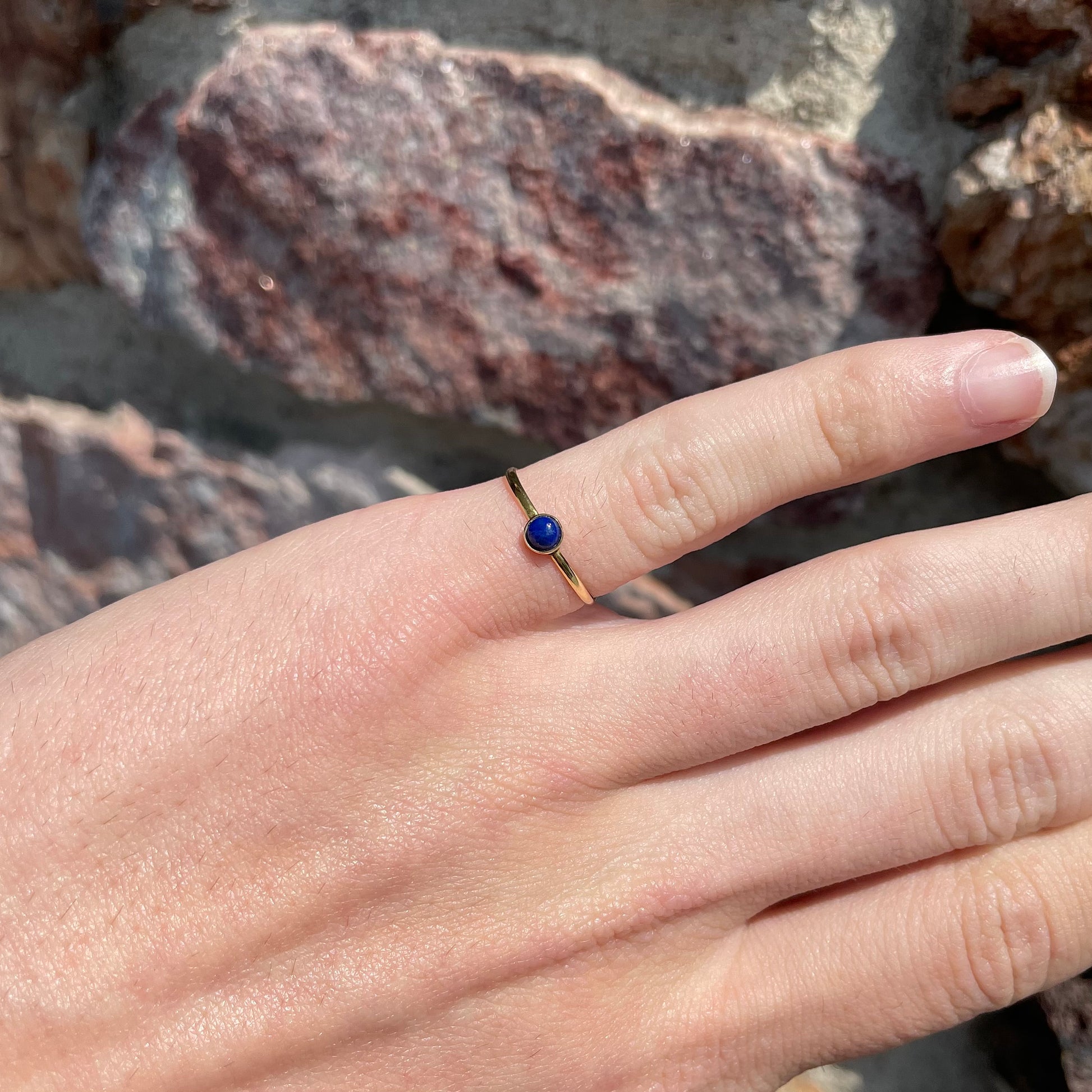 Round cabochon cut blue lapis lazuli stone set in a dainty simple yellow gold solitaire ring.