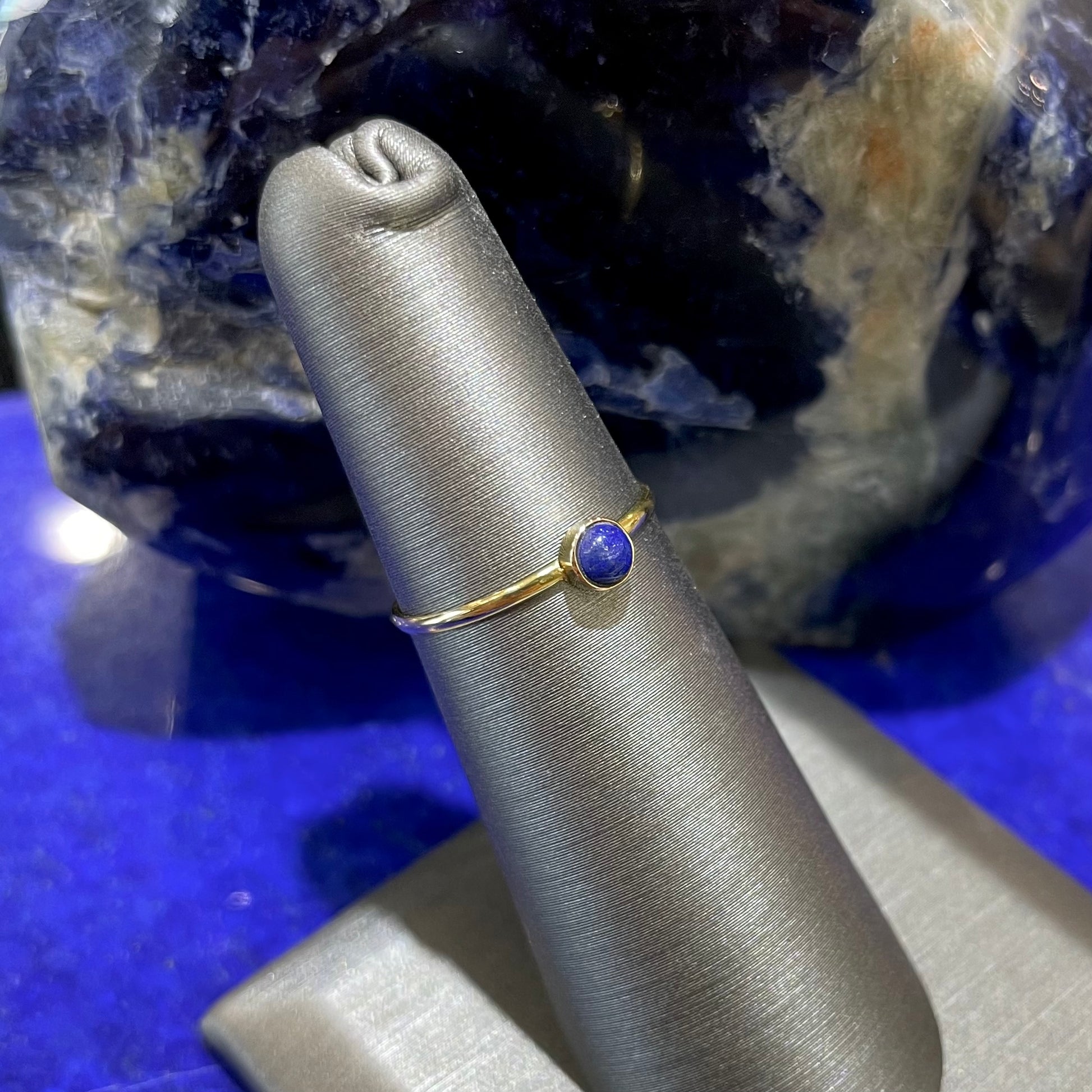 Round cabochon cut blue lapis lazuli stone set in a dainty simple yellow gold solitaire ring.